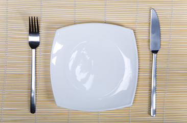Fork, Knife and  White Plate on Wood Background