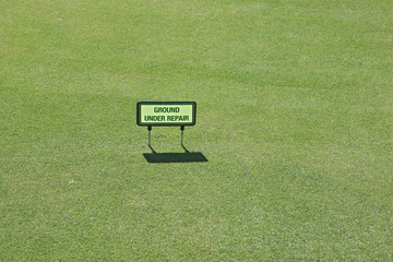 Hinweistafel auf Grün eines Golfplatzes