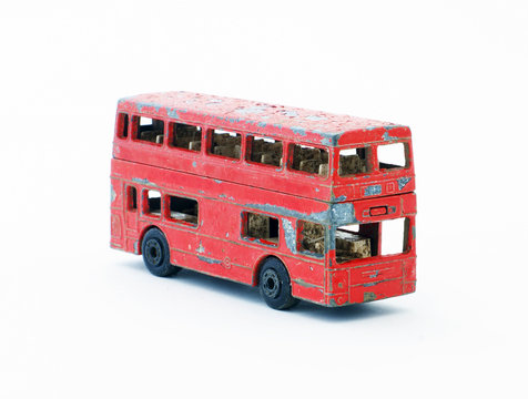 Old red paint peeling toy double decker bus.