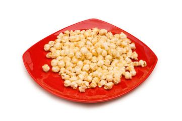 Popcorn on red plate isolated on white