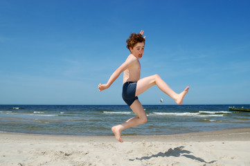 Fototapeta na wymiar Boy playing on beach