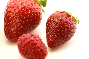 closeup of strawberries and raspberry with white background