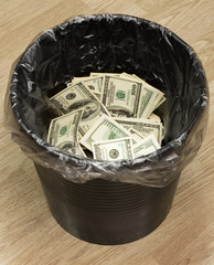 A money is in a trash bucket