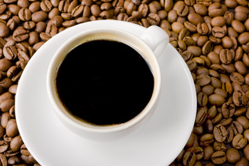 Cup Filled with Coffee on Coffee Beans