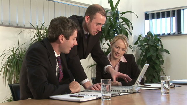 A businessman discusses a project with two other business people