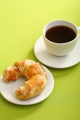 Breakfast concept with coffee and croissant