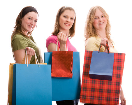 Three beautiful girls with shopping bags. Isolated on white
