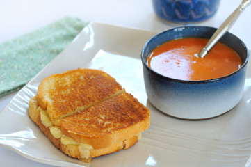 Grilled cheese and tomato bisque on plate with spoon