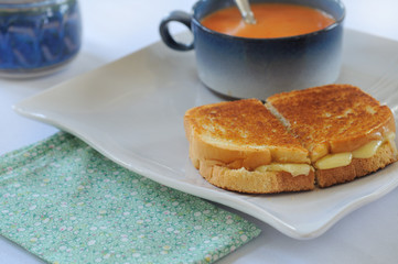 Grilled cheese and tomato bisque on plate with spoon