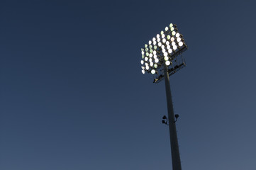 Lit stadium lights against evening sky