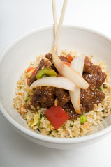 Bowl of fried rice topped with chicken and vegetables