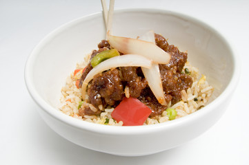 Bowl of fried rice topped with chicken and vegetables