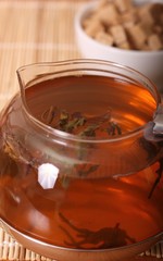 glass teapot with  tea leaves and sugar