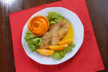 a plate of delicious juicy pork chop served with orange