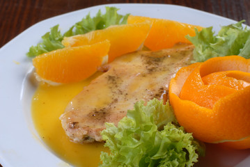 a plate of delicious juicy pork chop served with orange