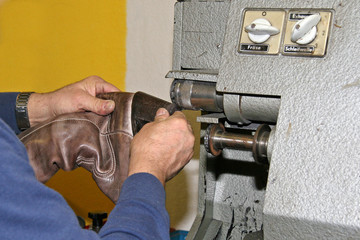 Schuhmacher bearbeitet Stiefelabsatz