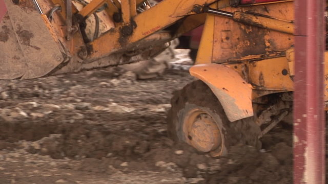 Footage of a bulldozer working with sand anda stones