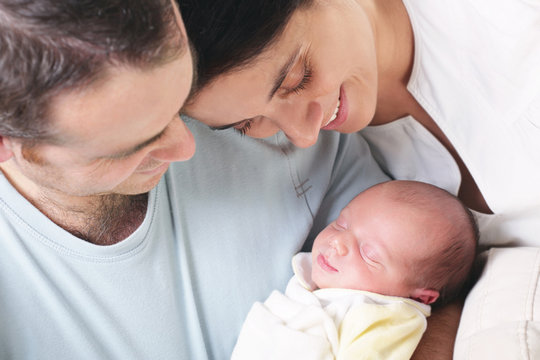 close-up of happy parents holding their newborn baby