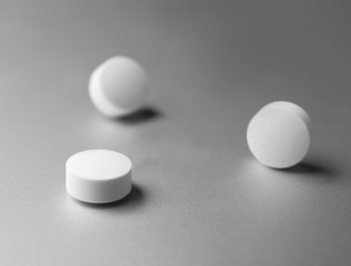 Three pills at silver background