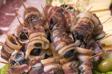 Rolled and roasted bacon with plum, and ham,olive,cheese