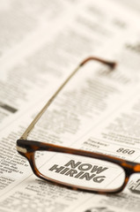 Glasses highlighting NOW HIRING classified ad