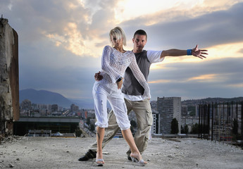 Fototapeta premium romantic urban couple dancing on top of bulding