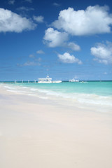 Fototapeta na wymiar Pier and Ferry Boat in a Tropical Ocean, White Sand Beach