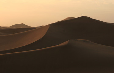 Fototapeta na wymiar Hiker obserwując zachód słońca na pustyni