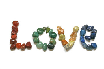 Love written in tumbled stones on white background