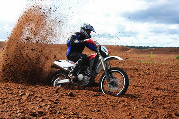 Off-road motorbike driving in dirt.