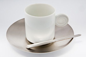 White coffe cup with metal saucer on white.