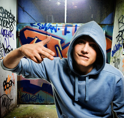 Cool looking hooligan in a graffiti painted gateway
