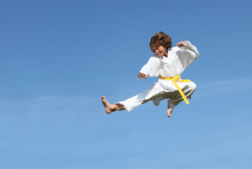 healthy fit kid doing karate leap or kick