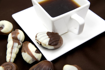 chocolate sweetmeats in form seashell and cup of coffe