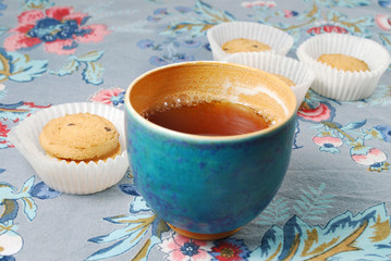 Teeschale mit Gebäck auf bunter Tischdecke