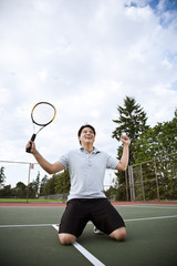 Asian tennis player in joy after winning