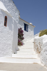 Fototapeta na wymiar Curved ścieżka obok białych ścianach Skopolos budynku w pobliżu wyspy S