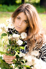 Naklejka premium beautiful woman in garden with roses