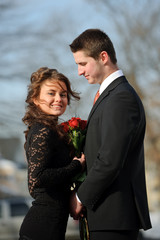 The young man gives to the girl flowers