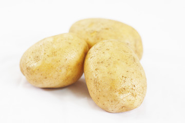 Close up of Three Potatoes on White Background