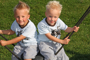 Jungen auf der schaukel auf dem spielplatz
