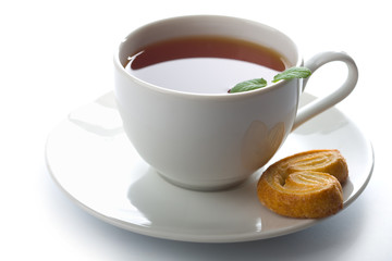 cup of tea with mint and cookie isolated