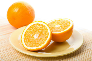 ripe oranges in yellow plate isolated