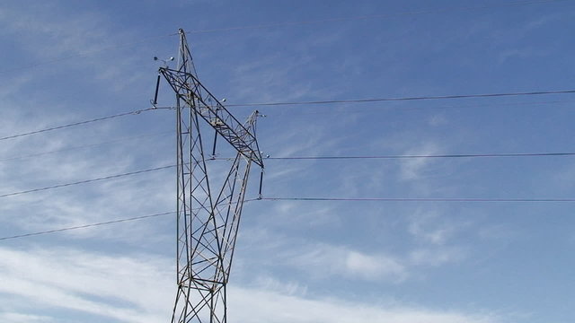 Electricity pylon and cables in green field