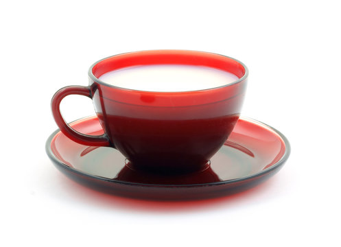 Red cup and saucer filled with skim milk.
