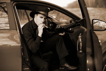 man in car with cigar and rifle
