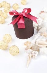 Holiday gift with red riband and various seashells