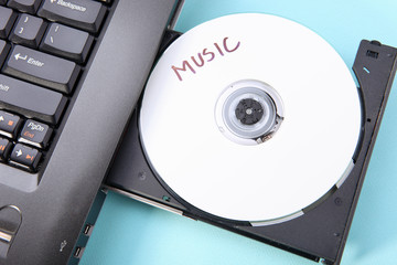 Closeup image of a laptop and a CD / DVD disc