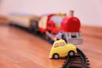 Fototapeta premium Red toy train and yellow toy car on railroad