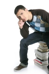 Obraz premium Young student boy sitting over stack books